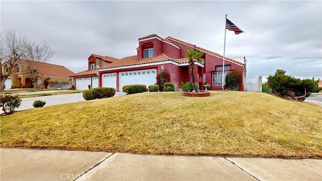 view of front of house with stucco siding, driveway, a tile roof, a front yard, and a garage