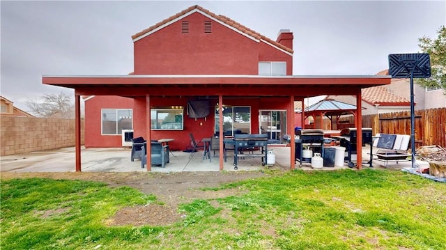 back of house with a gazebo, a yard, a fenced backyard, and a patio area