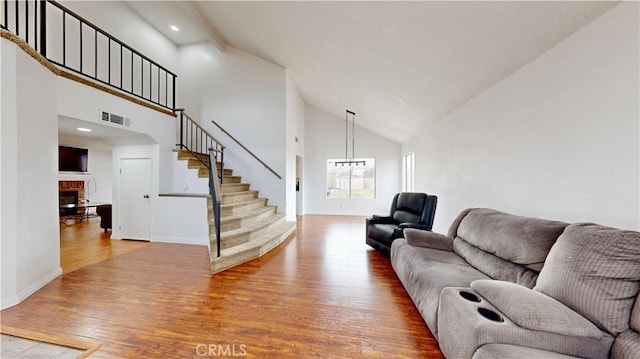 living area with stairway, visible vents, baseboards, a fireplace, and hardwood / wood-style flooring