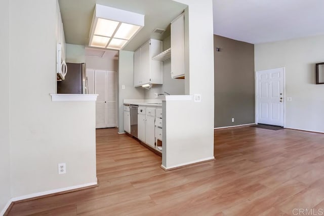 kitchen with light wood-style floors, appliances with stainless steel finishes, white cabinets, and light countertops