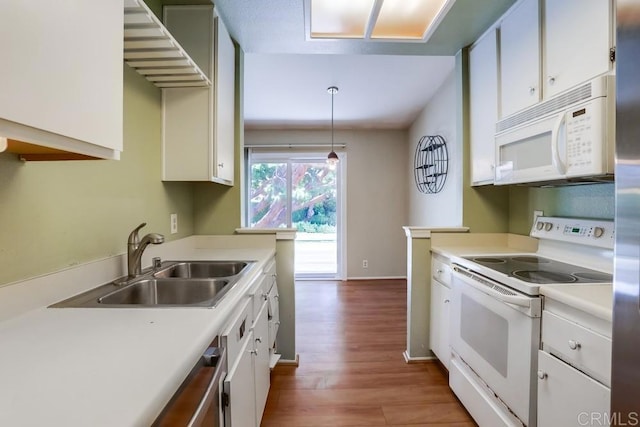 kitchen with a sink, white appliances, and white cabinetry