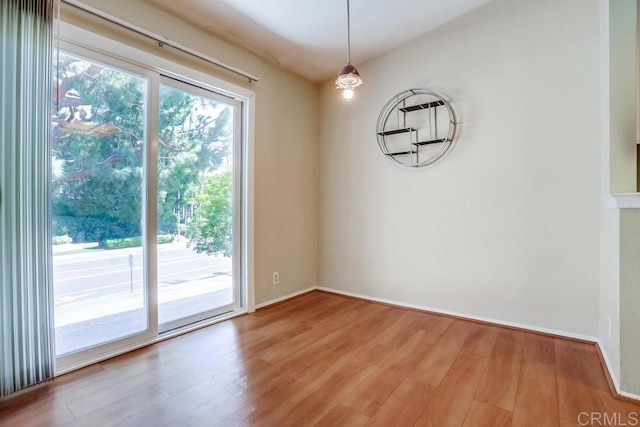 unfurnished room featuring baseboards and wood finished floors