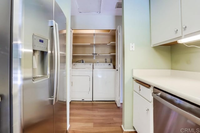 laundry area featuring laundry area, light wood-style flooring, and washer and clothes dryer