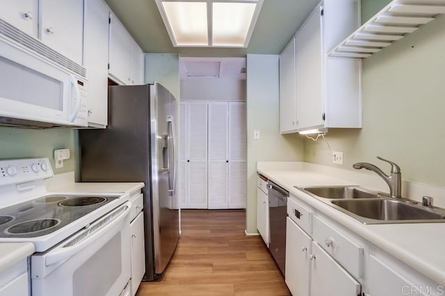 kitchen featuring light wood-style flooring, a sink, white cabinetry, white appliances, and light countertops