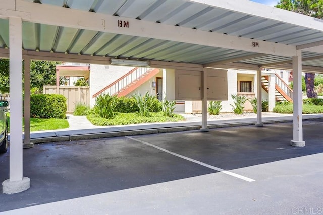 covered parking lot featuring stairway