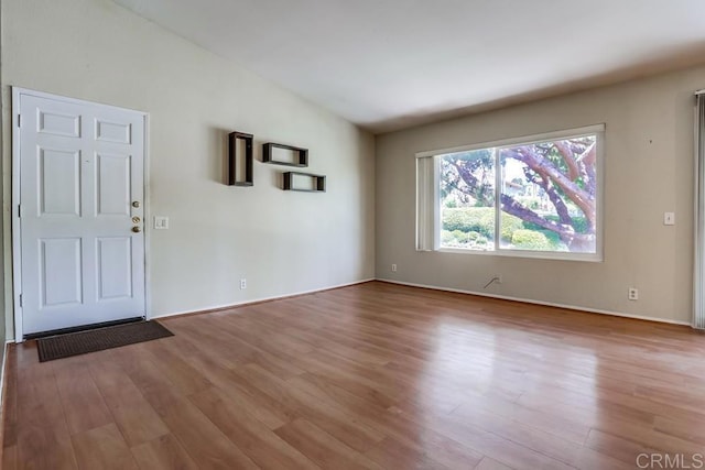 interior space with light wood finished floors and vaulted ceiling