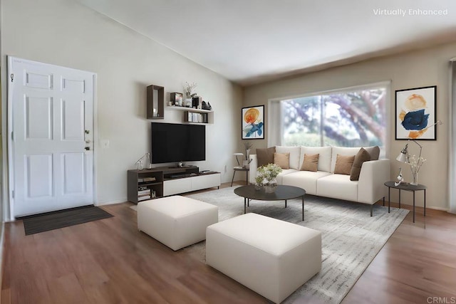 living room featuring vaulted ceiling, baseboards, and wood finished floors