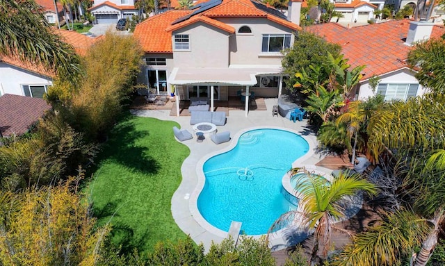 outdoor pool with a yard and a patio area