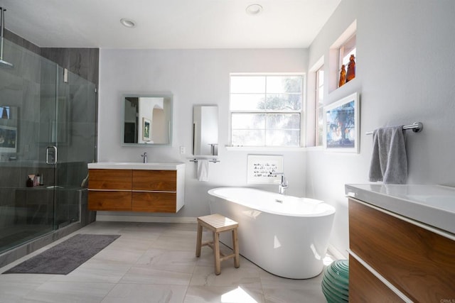 full bathroom featuring vanity, a soaking tub, recessed lighting, a shower stall, and marble finish floor