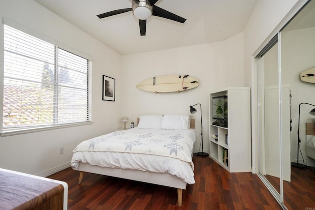 bedroom featuring a closet, a ceiling fan, baseboards, and wood finished floors