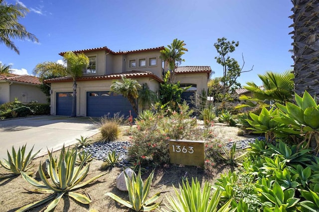 mediterranean / spanish house featuring a tile roof, driveway, and stucco siding