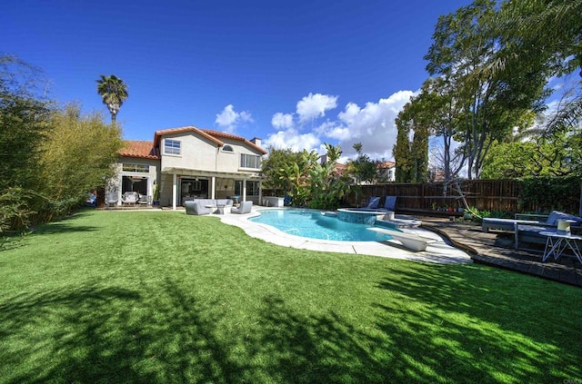 view of swimming pool with a patio area, a lawn, a pool with connected hot tub, and a fenced backyard