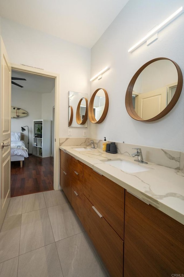 ensuite bathroom featuring a sink, double vanity, and connected bathroom