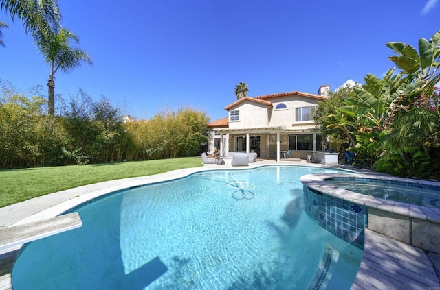 outdoor pool with a patio area, a lawn, an in ground hot tub, and a diving board