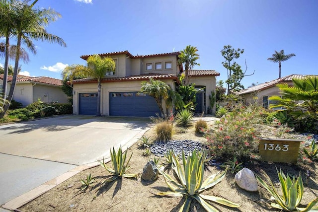 mediterranean / spanish-style home featuring a tiled roof, a garage, driveway, and stucco siding