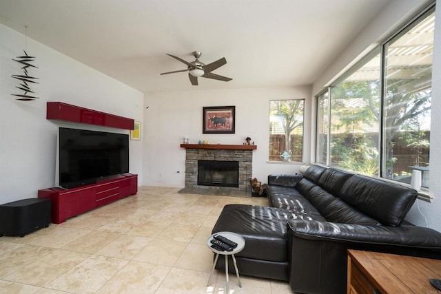 living room featuring tile patterned floors, a stone fireplace, and ceiling fan