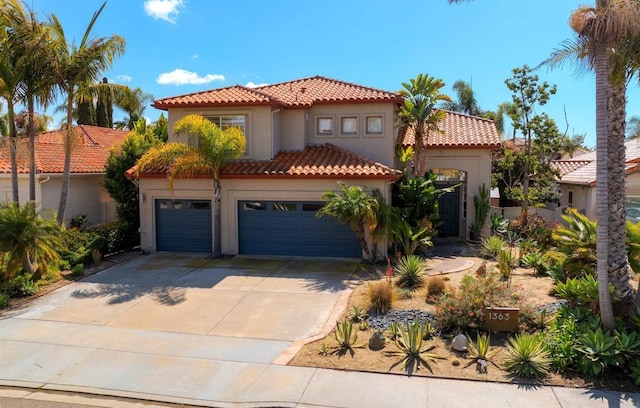 mediterranean / spanish home featuring stucco siding, a tiled roof, concrete driveway, and a garage