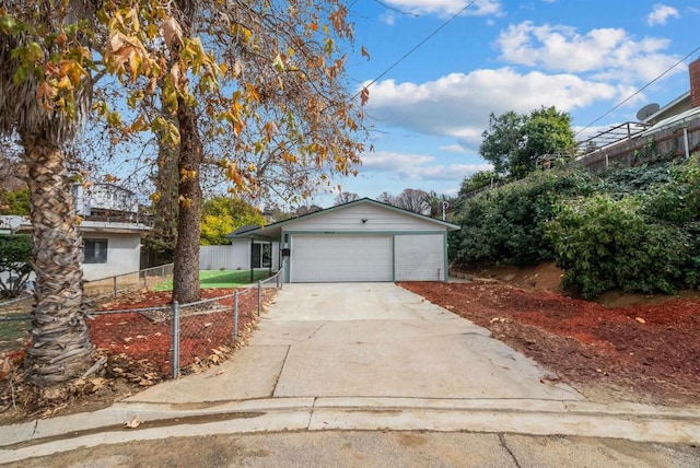 view of front of property featuring a garage, concrete driveway, and fence