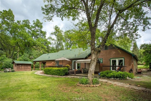 back of property with a storage unit, a yard, a wooden deck, and an outdoor structure