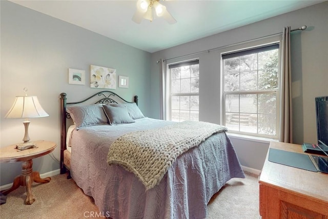 bedroom featuring baseboards, light colored carpet, and a ceiling fan