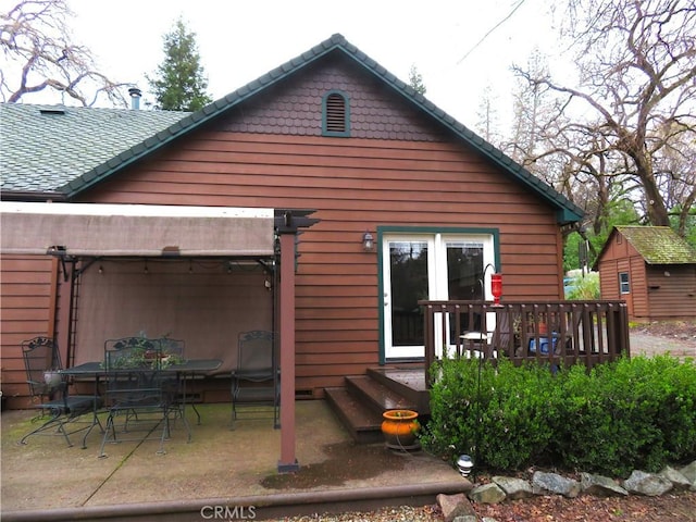 rear view of property featuring a patio area, outdoor dining area, and a deck