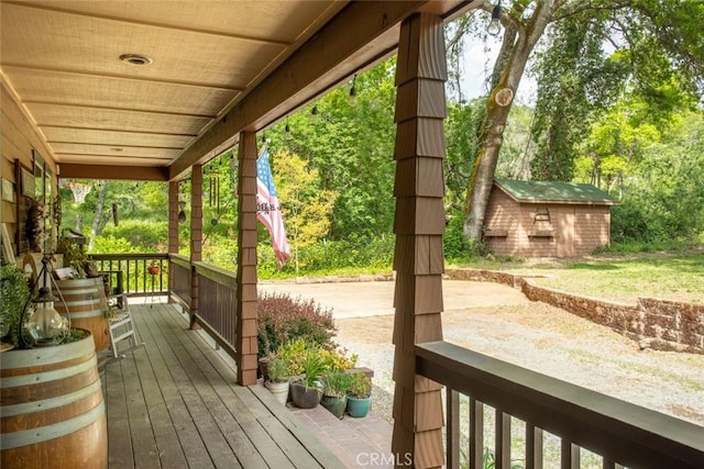 wooden deck with covered porch and an outdoor structure