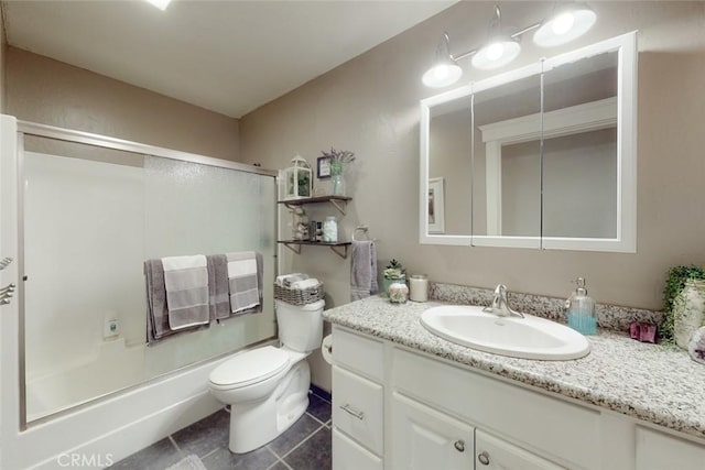 bathroom featuring vanity, toilet, tile patterned flooring, and bath / shower combo with glass door