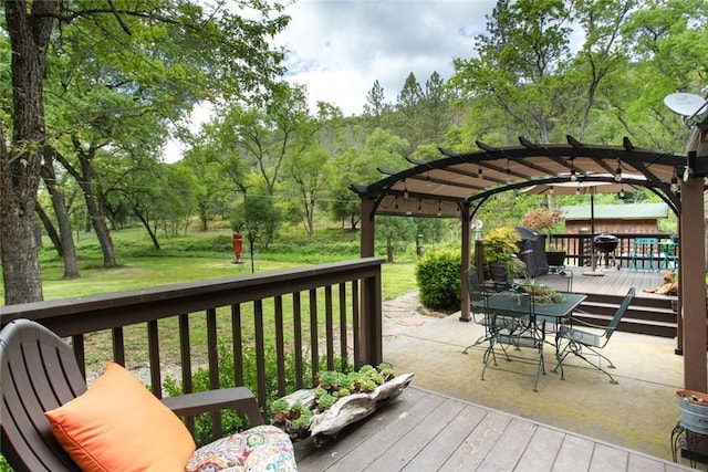 deck featuring a lawn, a pergola, and outdoor dining area