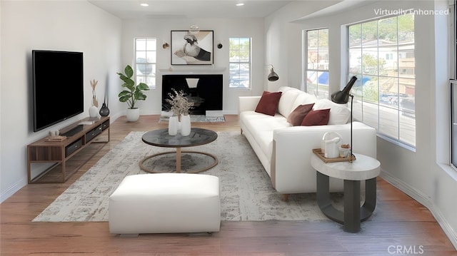 living room with recessed lighting, baseboards, wood finished floors, and a fireplace