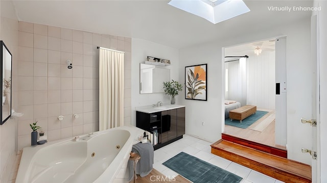 full bathroom featuring vanity, a skylight, ensuite bathroom, tile patterned floors, and tile walls