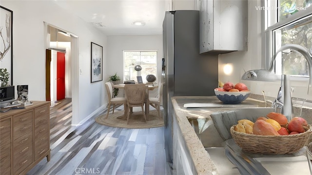 kitchen with visible vents, baseboards, wood finished floors, and white cabinets