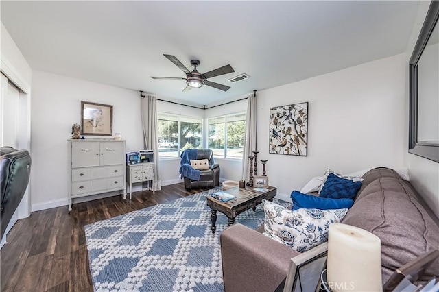 living room featuring baseboards, visible vents, dark wood-style flooring, and ceiling fan