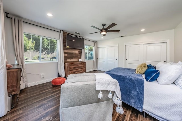 bedroom featuring visible vents, multiple closets, dark wood finished floors, recessed lighting, and baseboards