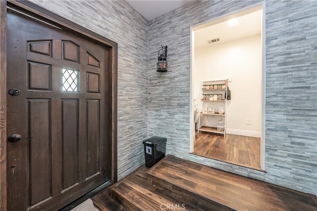 foyer featuring dark wood-style floors, visible vents, and baseboards