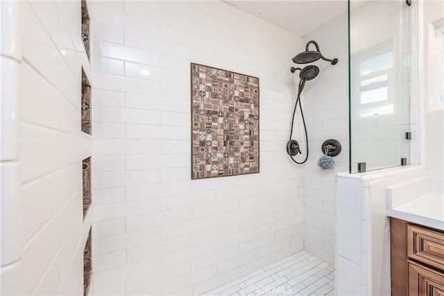 bathroom featuring tiled shower and vanity