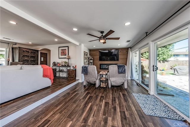 living area with arched walkways, recessed lighting, and wood finished floors