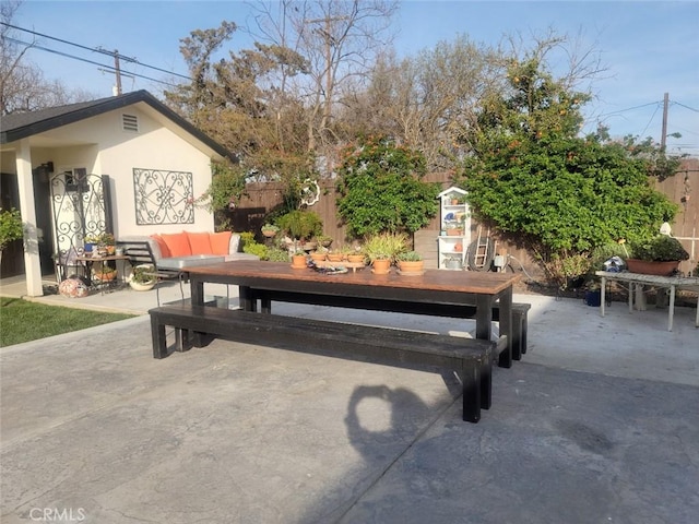 view of patio with outdoor dining space and fence