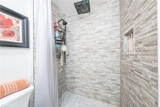 bathroom featuring toilet and tiled shower