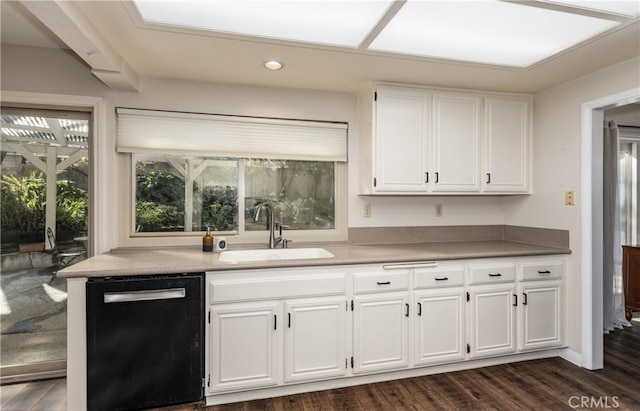 kitchen with dark wood finished floors, white cabinets, dishwasher, and a sink