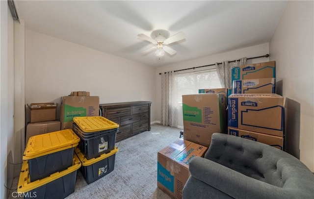 living area featuring carpet flooring, baseboards, and ceiling fan