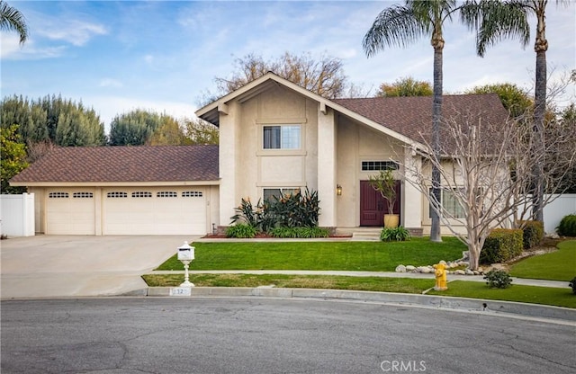 view of front facade with stucco siding, a front lawn, a garage, and driveway