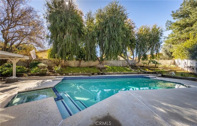 view of swimming pool with a patio area, a pool with connected hot tub, and a fenced backyard