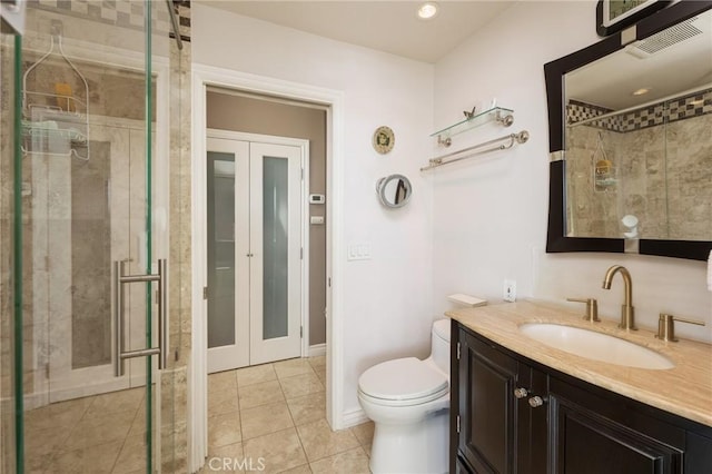 bathroom with toilet, a stall shower, french doors, tile patterned flooring, and vanity