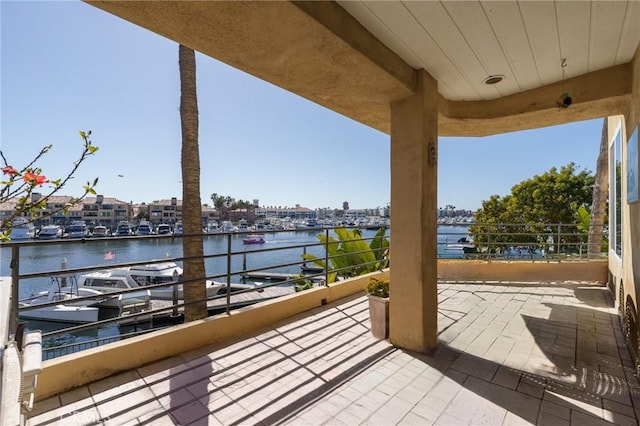 view of patio with a water view and a balcony