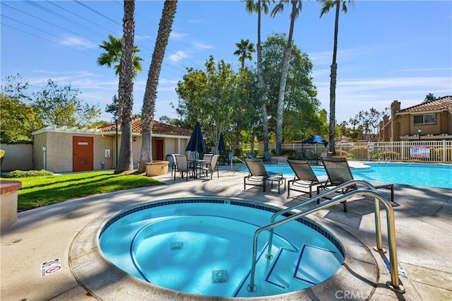 pool featuring a patio area, a community hot tub, and fence