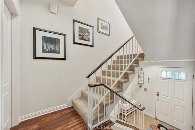 stairs featuring wood finished floors and baseboards