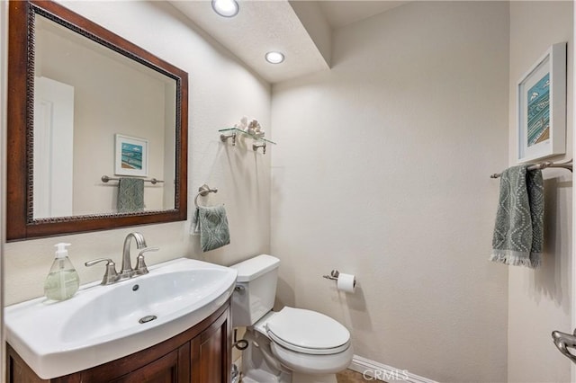 half bath with recessed lighting, toilet, and vanity