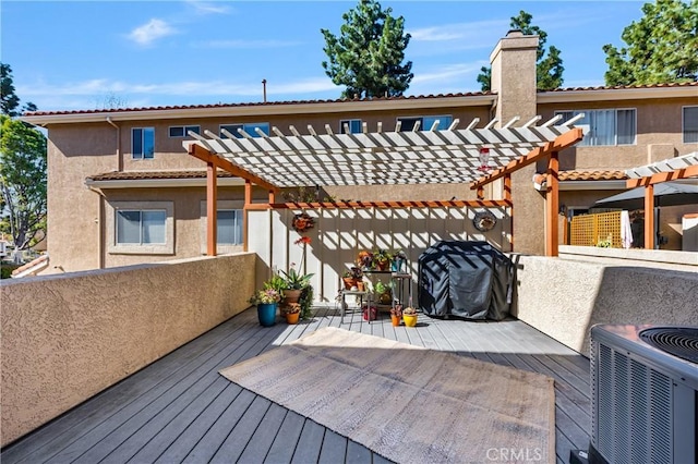 wooden deck with area for grilling and a pergola