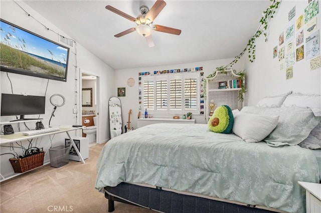 bedroom with lofted ceiling, a ceiling fan, ensuite bath, and carpet flooring