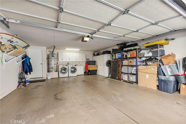 garage with a garage door opener, secured water heater, and washing machine and dryer